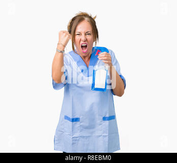 Middle age brunette cleaner woman wearing housework uniform over isolated background annoyed and frustrated shouting with anger, crazy and yelling wit Stock Photo