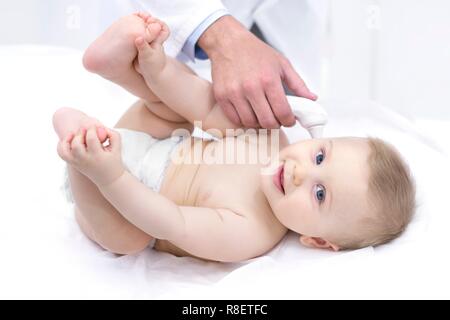 Doctor taking baby's temperature using digital thermometer. Stock Photo