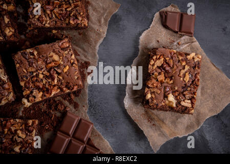 Delicious homemade chocolate cake decorated with walnuts. Freshly baked brownie cake on a rustic wooden table Stock Photo