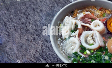 Chinese squid noodle soup with brown egg, green onion and sweet potatos. Stock Photo