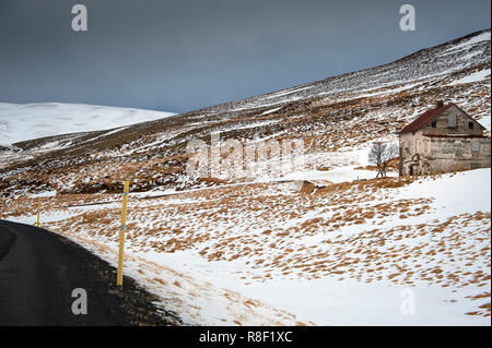 Old abandoned building stands in a snow covered landscape, West Fjords region, Iceland. Stock Photo