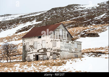 Old abandoned building stands in a snow covered landscape, West Fjords region, Iceland. Stock Photo