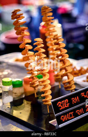 Fried twisted potato - traditional asian street food. Asian, Indian and Chinese street food. Food court on local market of Langkawi island, Malaysia. Stock Photo