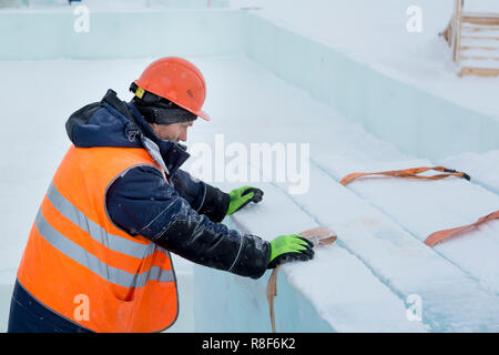 Worker fitter in a protective helmet and reflective vest on the working meast Stock Photo