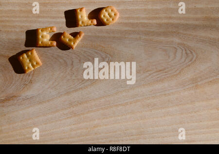 Hello. Text from the salty crackers as printed English letters that lie on a wooden chopping board. Message, lined with edible letters Stock Photo
