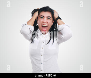 Frustration. Frustrated and stressed young businesswoman screaming. Beautiful young mixed race Asian woman isolated on white background Stock Photo