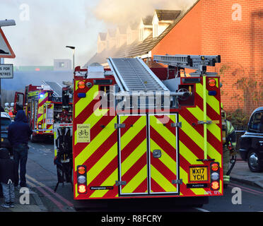 Emergency services respond to a house fire in a residential street in East London with a number of Fire Engines including an Aerial Platform Stock Photo