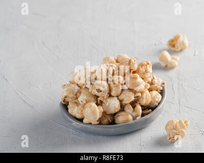 popcorn in gray craft trendy plate on gray concrete background. Moovie background with copy space. Top view or flat lay. Stock Photo