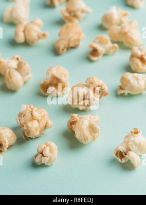 popcorn on blue background. Movie background with copy space. Vertical. Selective focus. Stock Photo