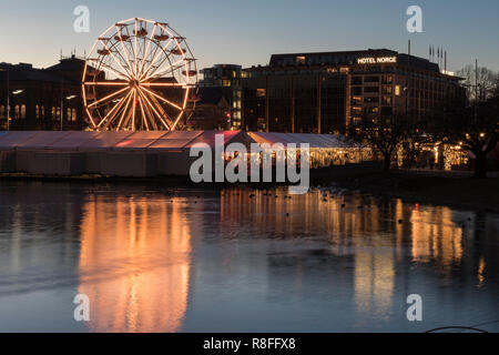 Christmas Market by Lille Lungegaardsvannet Lake in downtown Bergen, Norway. Ferris wheel rotating. Stock Photo