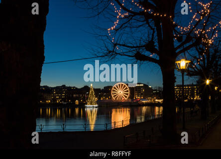 Christmas tree and Market by Lille Lungegaardsvannet Lake in downtown Bergen, Norway. Ferris wheel rotating. Stock Photo