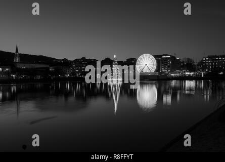 Christmas tree and Market by Lille Lungegaardsvannet Lake in downtown Bergen, Norway. Ferris wheel rotating. Stock Photo