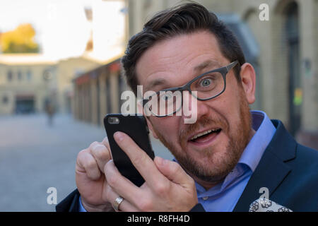 Crazy Business man surprised by message on mobile Stock Photo