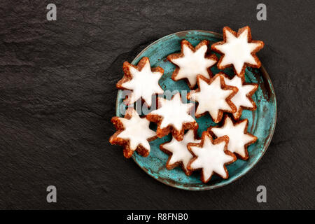Christmas Zimtsterne, traditional German almond, chocolate and cinnamon star cookies, shot from the top on a dark background with copy space Stock Photo