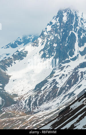 June view from the Karlesjoch Alps mountain (3108 m, near Kaunertal Gletscher on Austria-Italy border) over precipice and clouds. Stock Photo