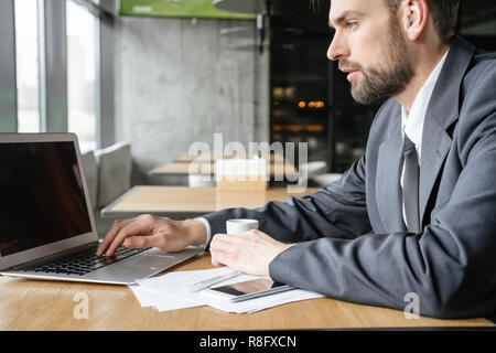 Businessperson on business lunch at restaurant sitting browsing laptop side view Stock Photo