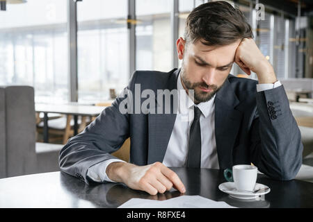 Businessperson on business lunch at restaurant sitting drinking hot coffee thinking of problem Stock Photo