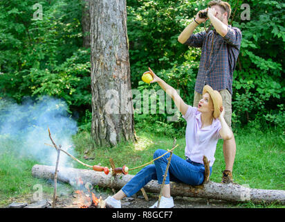 Couple enjoy hike in forest observing nature. Couple ornithologists expedition in forest. Observing nature concept. Ornithology interesting occupation. Woman and man looking binoculars near bonfire. Stock Photo
