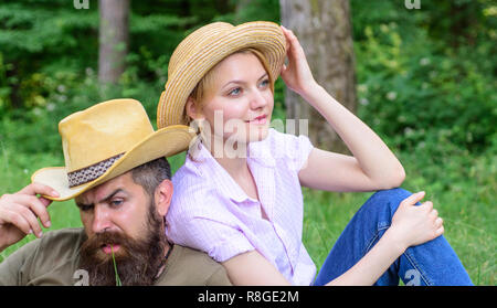 Choose proper clothing and equipment to hike and forest picnic. Couple tourists wearing hats. Couple in straw hats sit meadow relaxing. Hats for tourism. Reasons you should definitely wear more hats. Stock Photo