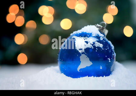 Christmas ornaments in snow with sparkling lights in the background Stock Photo
