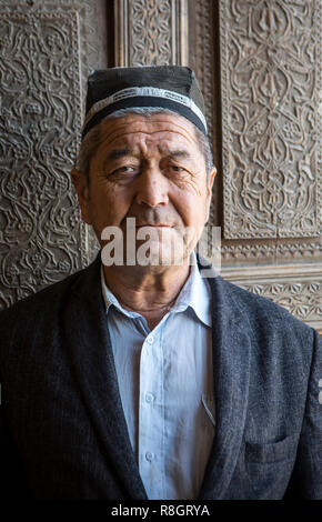 Uzbek man, vigilant of Rukhobod Mausoleum, Samarkand, Uzbekistan Stock Photo