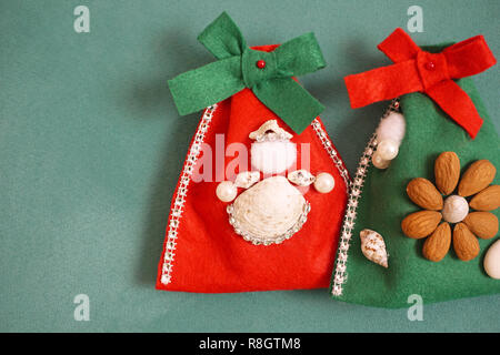 Felt homemade Christmas gift bags decorated with angel made from seashells, beads and almonds Stock Photo