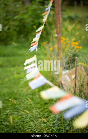 Tibetan prayer flags hanging in a community garden in Lincoln, Massachusetts. Stock Photo