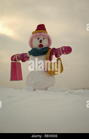 Snowman in pink wig, mittens, hat and scarf. Stock Photo