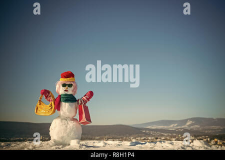 Snowman in pink wig, mittens, hat, glasses and scarf. Stock Photo