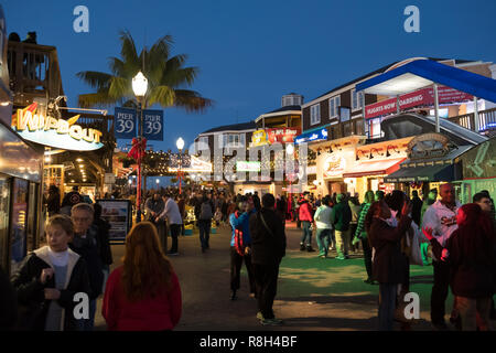 San Francisco, US - NOV 24, 2018: Visitors walk on Pier 39 stores and restaurants in evening at Fishermans wharf, San Franscisco. Stock Photo