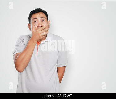 Photo image portrait of a cute handsome young Asian man crying hard of sadness, close his mouth with his hand gesture Stock Photo