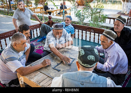 Men playing domino, chaijana, traditional tea house, in Lyabi-Hauz square, Bukhara, Uzbekistan Stock Photo