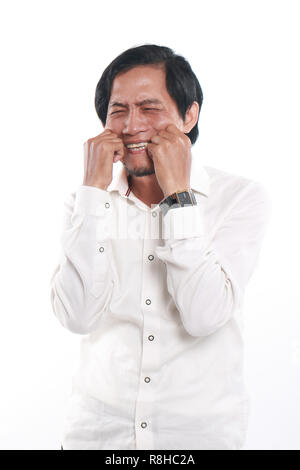Photo image portrait of a funny young Asian businessman crying, close up portrait over white Stock Photo