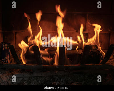 Firestarter log sitting in household fireplace burning brightly controlled manner Stock Photo