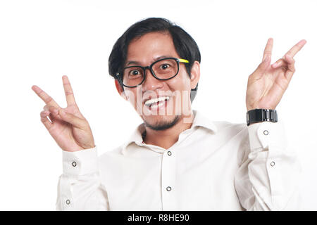 Photo image portrait of a funny young Asian businessman wearing glasses looked very happy, close up portrait, big smile with both hand showing peace s Stock Photo