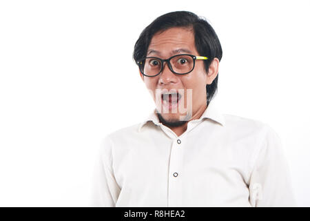 Photo image portrait of a funny young Asian businessman with glasses looked very shocked, close up portrait with surprised gesture, over white backgro Stock Photo