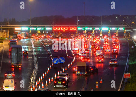 Severn Bridge, Wales, UK.  15th December 2018.  Traffic queuing at dusk for the toll as work continues to remove three of the the Severn Bridge toll booths on the M4 Motorway in Wales, UK ahead of the tolls being scrapped from Monday 17th December when it will be free to cross the bridge.  Picture Credit: Graham Hunt/Alamy Live News Stock Photo
