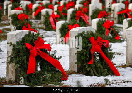 Christmas wreaths decorate the gravesites of service members during the 27th National Wreaths Across America Day at Sackets Harbor Military Cemetery December 15, 2018 in Sackets Harbor, New York. Stock Photo
