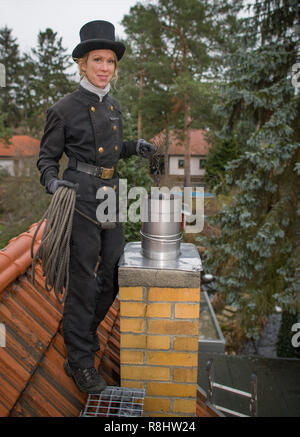 13 December 2018, Brandenburg, Königs Wusterhausen: Stephanie Frenk, chimney sweep master, stands on the roof of a house. Stephanie Frenk likes to get her hands dirty and climbs on the roofs of houses: she is one of the few chimney sweeps in Brandenburg. Frenk has been a chimney sweep since 2007. Photo: Patrick Pleul/dpa-Zentralbild/ZB Stock Photo