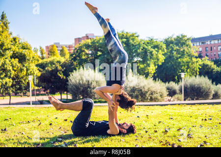 Beautiful couple practicing acro yoga in the morning Stock Photo