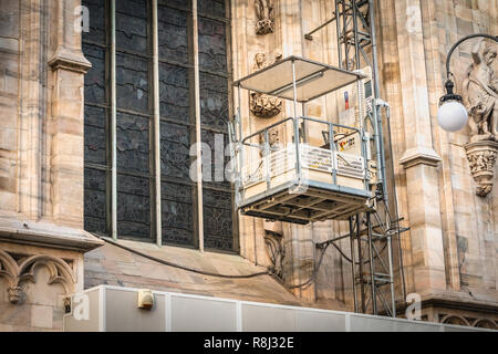 Milan, Italy - November 2, 2017: Construction elevator installed on Milan's Duomo Cathedral to make the renovation and maintenance work on a fall day Stock Photo