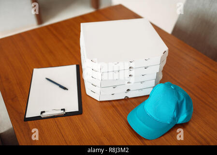 Carton pizza boxes, cap and empty order on table, top view. Pizza delivery business concept, fast delivering service, nobody Stock Photo