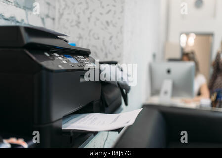 Copier with contract, equipment in business office, Secretary at the workplace on background. Printer on the table in company Stock Photo