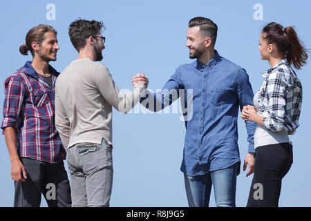 friends greet each other with a handshake Stock Photo