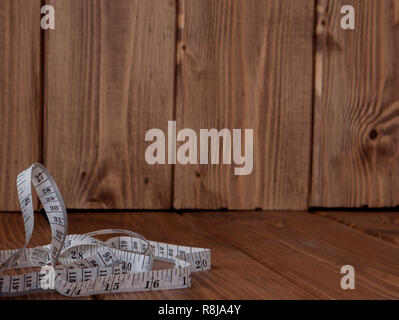 tape measure tangled on wooden background Stock Photo