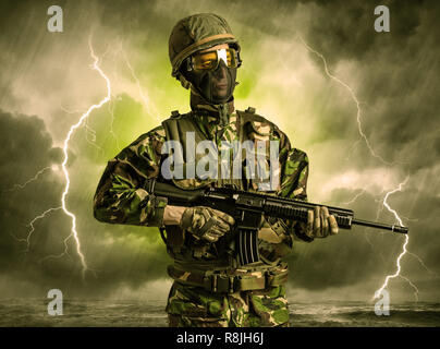 Armed soldier standing in rainy obscure weather  Stock Photo