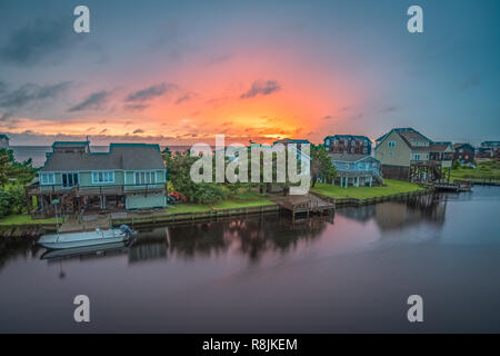 The sun sets behind a row of waterfront cottages on Hatteras Island, NC. Stock Photo