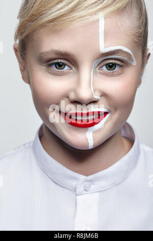 Portrait of a young smiling woman on gray background. Female with an unusual creative makeup and face painting. Stock Photo
