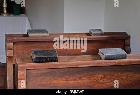 4 old prayer books in small chapel Stock Photo