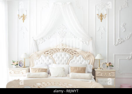Beautiful big bed in the bedroom in rococo style. Stock Photo
